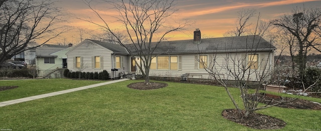 view of front facade featuring a yard and a chimney