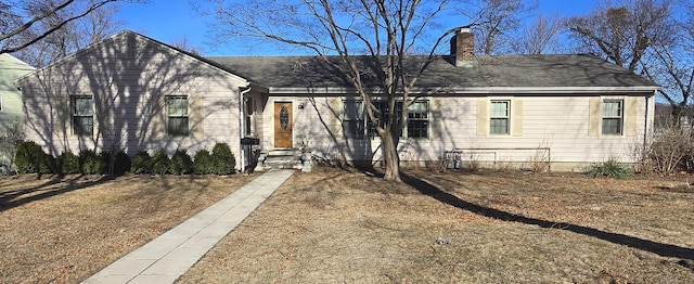 single story home with entry steps and a chimney