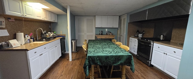 kitchen with stainless steel gas range oven, black dishwasher, dark wood-style flooring, and a sink