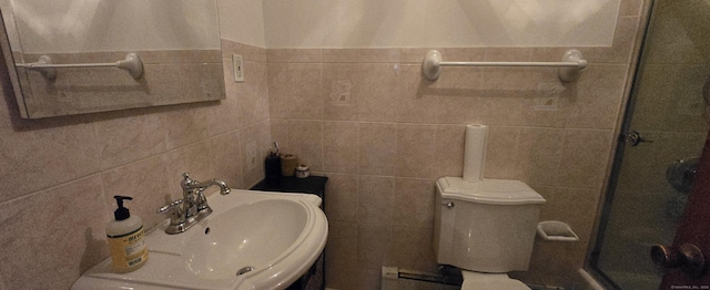 full bath featuring a shower stall, toilet, tile walls, and a sink