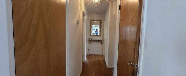 hallway with wood finished floors and baseboards