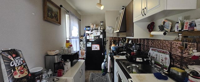 kitchen featuring freestanding refrigerator, a sink, light countertops, white cabinetry, and exhaust hood