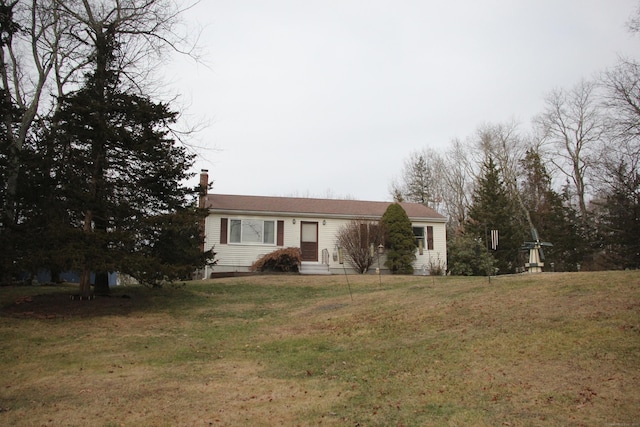 view of front of house with a chimney and a front yard