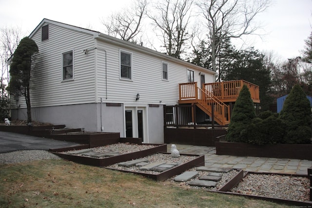 back of property with a deck, a patio, and stairway