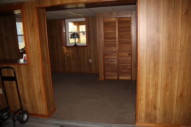 corridor with carpet floors and wooden walls