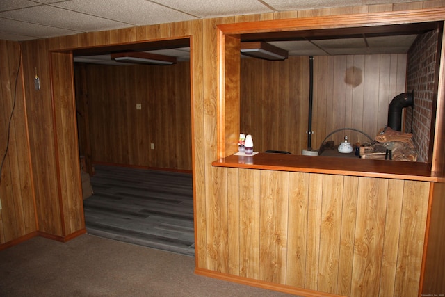 bar featuring baseboards, wood walls, carpet, and wet bar