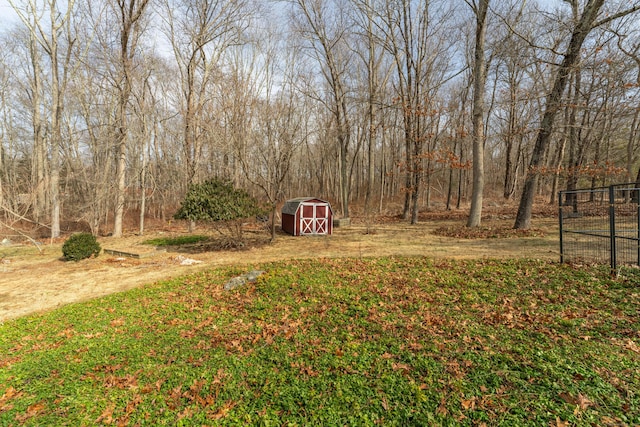 view of yard with driveway, a shed, fence, and an outdoor structure