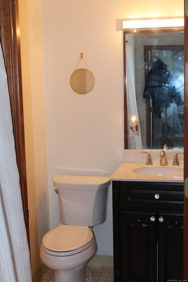 bathroom with toilet, tile patterned flooring, and vanity