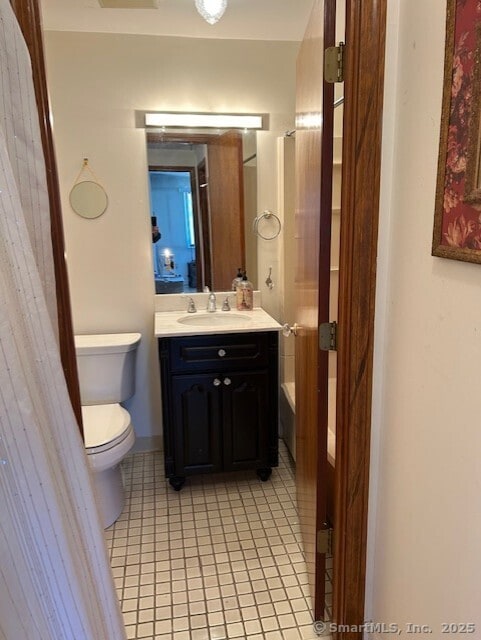 bathroom with a washtub, vanity, toilet, and tile patterned floors