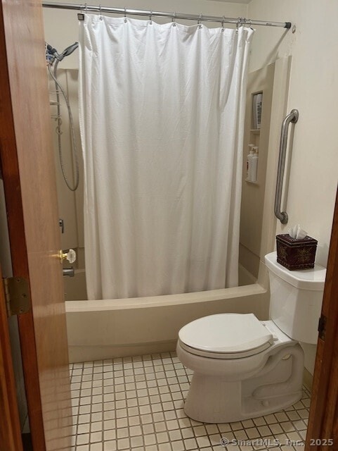 full bathroom featuring toilet and shower / bath combo with shower curtain