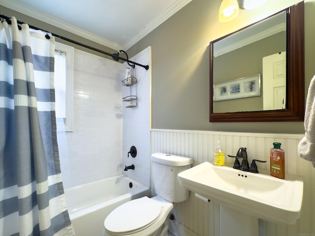 bathroom featuring toilet, a sink, wainscoting, shower / tub combo with curtain, and crown molding