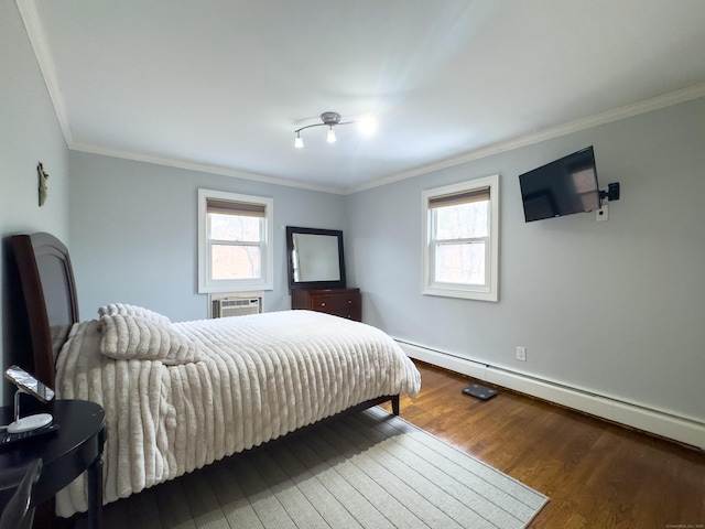 bedroom with multiple windows, baseboard heating, wood finished floors, and crown molding