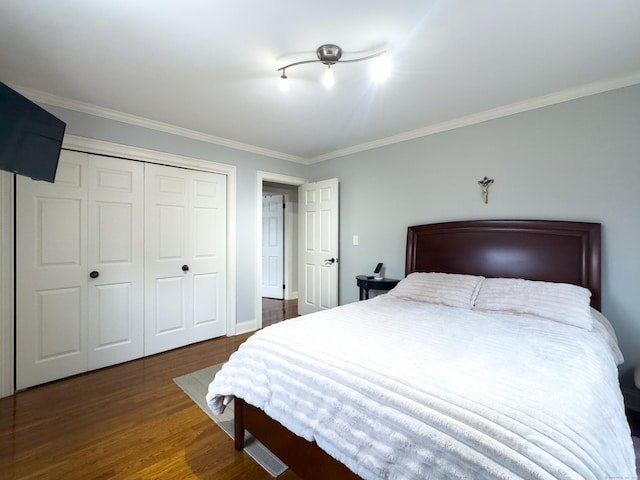 bedroom featuring a closet, wood finished floors, and crown molding