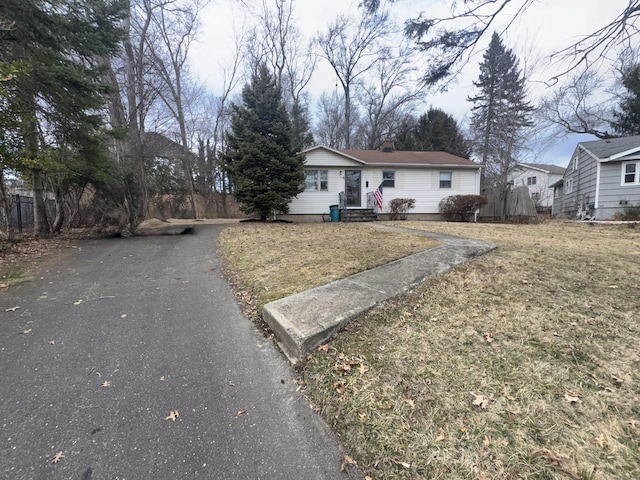 single story home featuring a front yard and a chimney