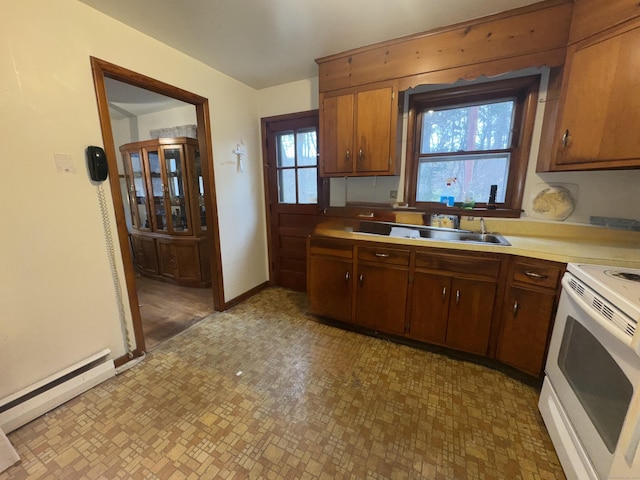 kitchen with electric stove, brown cabinets, a baseboard radiator, light countertops, and baseboards