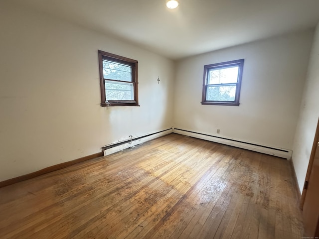 unfurnished room featuring hardwood / wood-style flooring and baseboards