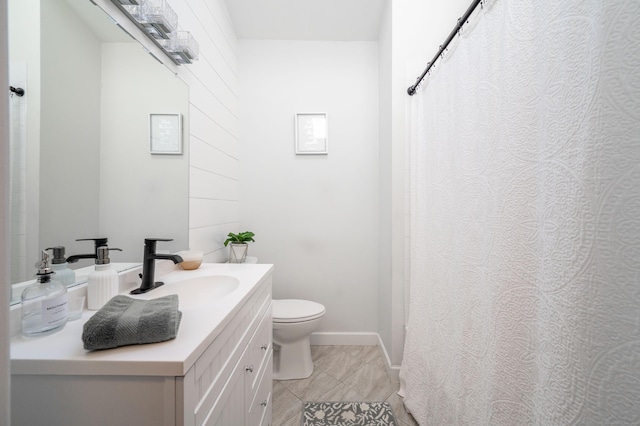 bathroom with tile patterned flooring, baseboards, vanity, and toilet