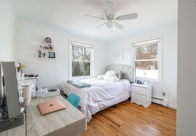 bedroom with light wood-type flooring, multiple windows, baseboard heating, and a ceiling fan