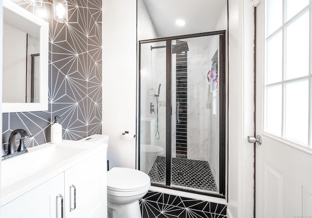 bathroom featuring a stall shower, plenty of natural light, vanity, and toilet