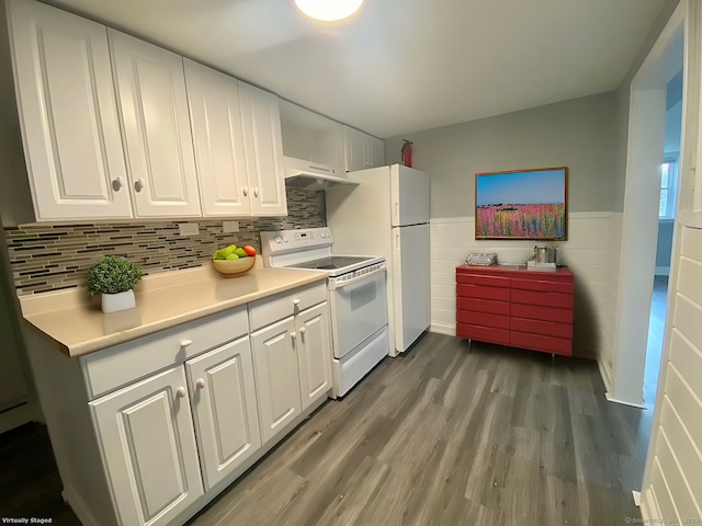 kitchen featuring white appliances, wainscoting, under cabinet range hood, and white cabinetry