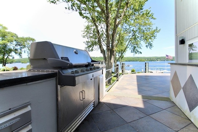 view of patio featuring an outdoor kitchen and a water view