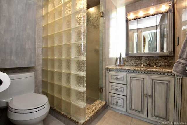 bathroom featuring a stall shower, tile patterned flooring, vanity, and toilet