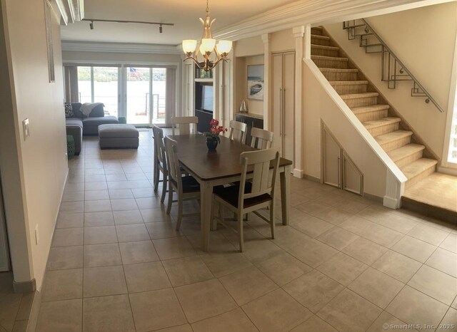 tiled dining room featuring stairs, ornamental molding, a chandelier, and track lighting