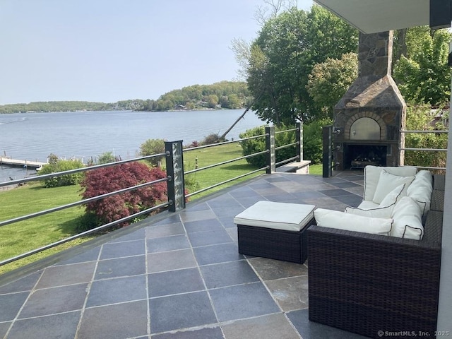 view of patio / terrace featuring an outdoor living space with a fireplace and a water view