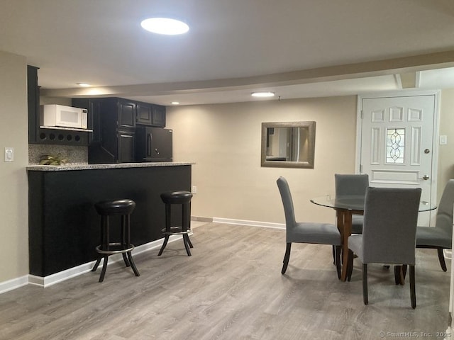 dining space featuring recessed lighting, light wood-style flooring, and baseboards