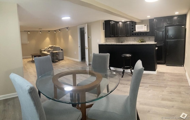 dining area featuring light wood-style flooring, baseboards, and recessed lighting