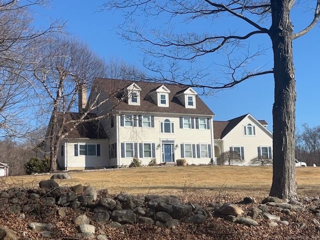 colonial home featuring a front lawn