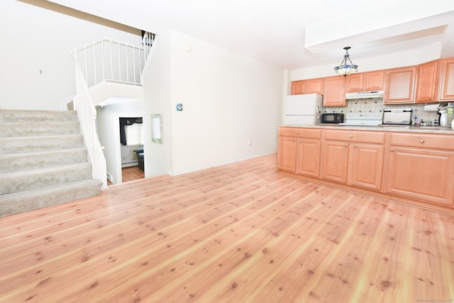 333 Vincellette St Unit 16, Bridgeport, CT 06606 - kitchen with freestanding refrigerator, black microwave, under cabinet range hood, light wood-style floors, and backsplash
