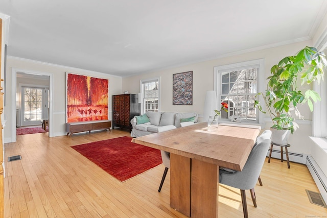 dining space with crown molding, visible vents, light wood finished floors, and a baseboard radiator