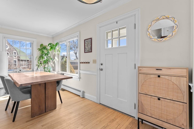 foyer entrance with baseboards, baseboard heating, ornamental molding, and light wood finished floors