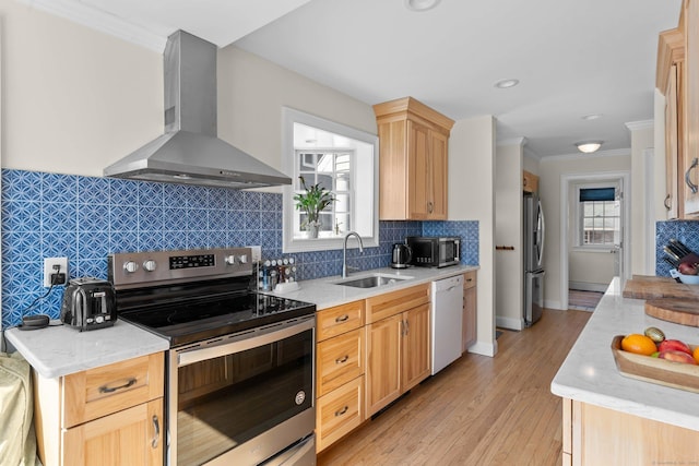 kitchen featuring ornamental molding, a sink, tasteful backsplash, appliances with stainless steel finishes, and wall chimney exhaust hood