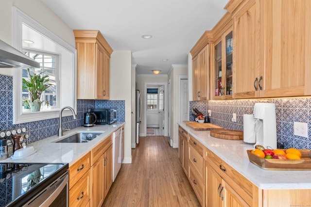 kitchen featuring baseboards, ornamental molding, freestanding refrigerator, white dishwasher, and a sink