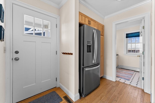 kitchen featuring a baseboard heating unit, visible vents, ornamental molding, and stainless steel fridge with ice dispenser