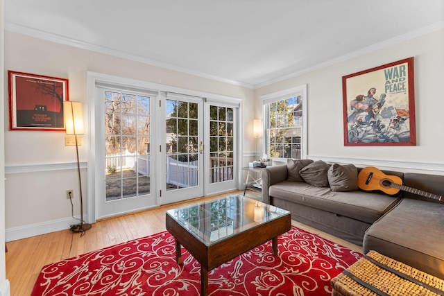 living room with hardwood / wood-style floors, baseboards, and ornamental molding