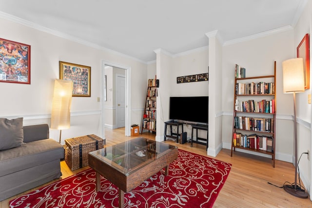 living area with crown molding, baseboards, and light wood-type flooring