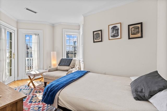 bedroom with access to exterior, crown molding, wood finished floors, and visible vents