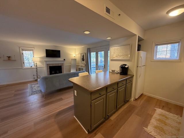 kitchen with freestanding refrigerator, baseboards, and wood finished floors