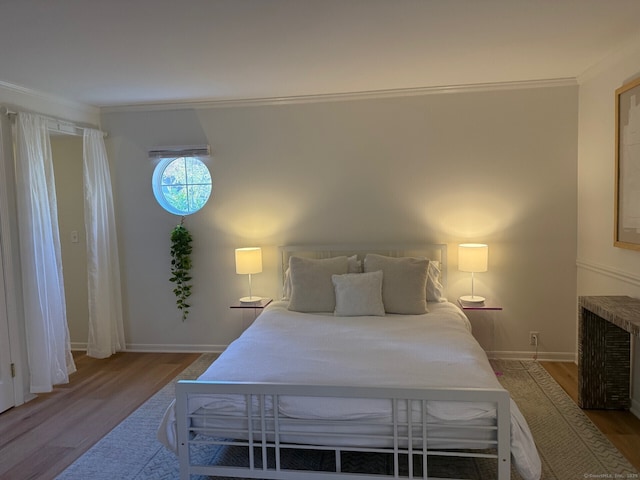 bedroom with baseboards, wood finished floors, and crown molding