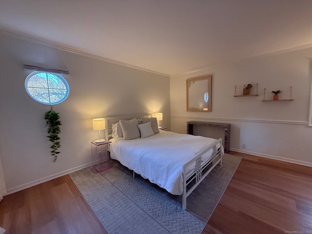 bedroom with ornamental molding, radiator heating unit, wood finished floors, and baseboards