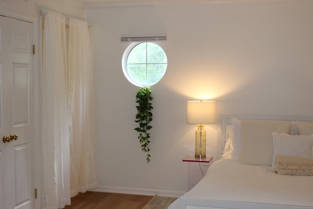 bedroom with baseboards and wood finished floors