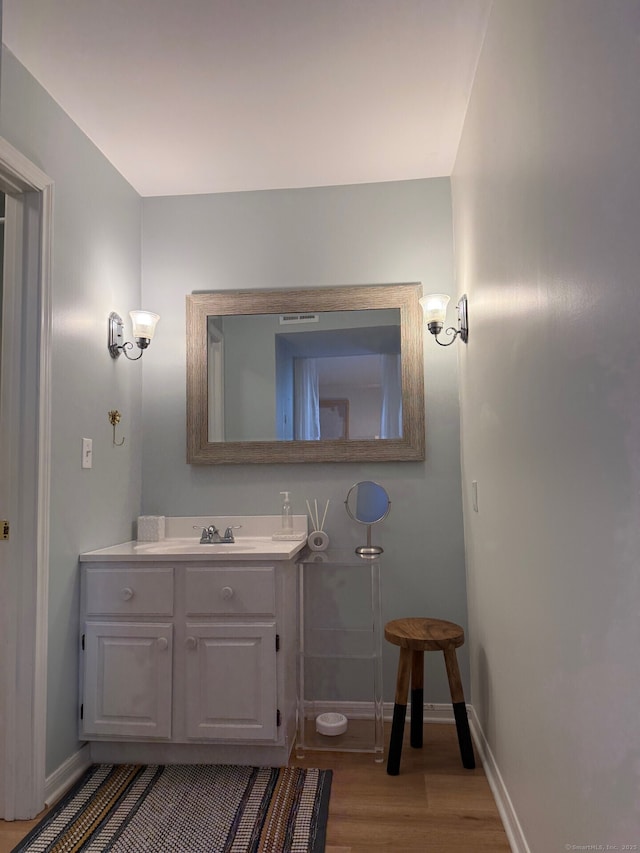 bathroom with vanity, baseboards, and wood finished floors