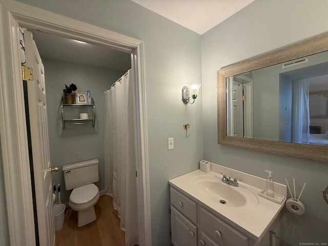 full bathroom with toilet, wood finished floors, and vanity