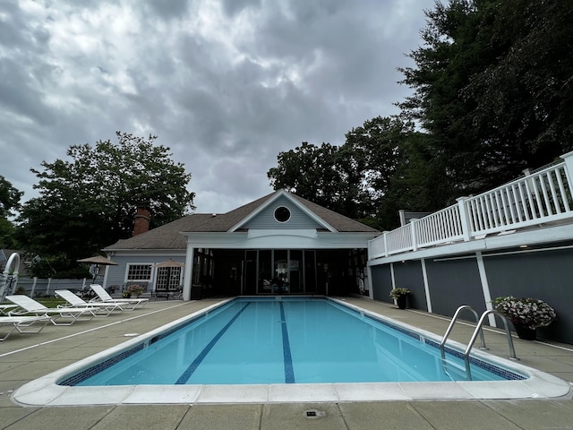 pool with a sunroom and a patio