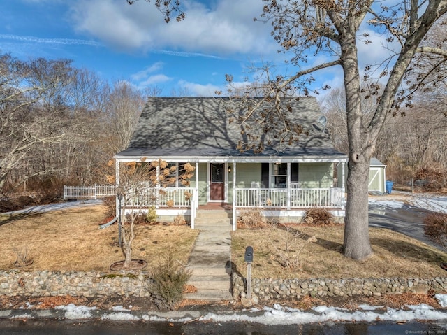 view of front facade featuring covered porch and roof with shingles