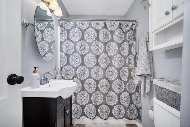 bathroom featuring toilet, vanity, and a shower with curtain