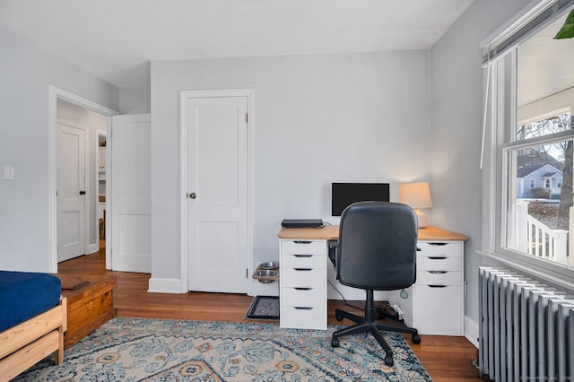 office with radiator heating unit, wood finished floors, and baseboards